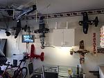Work area, light, old kitchen table, TV and planes on their brackets.