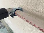 1" conduit clamp to attach PVC to the wall. They're called Minerallac clamps.